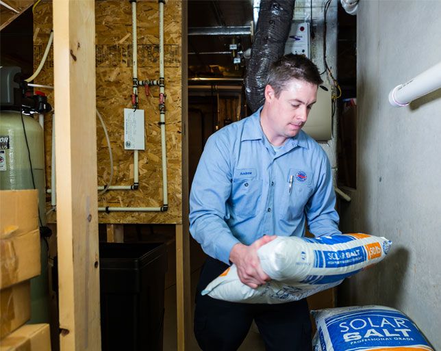 Technician lifting water softener bag