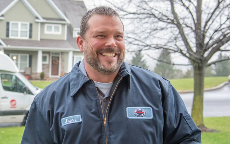 Male Haller tech smiling in customer front yard