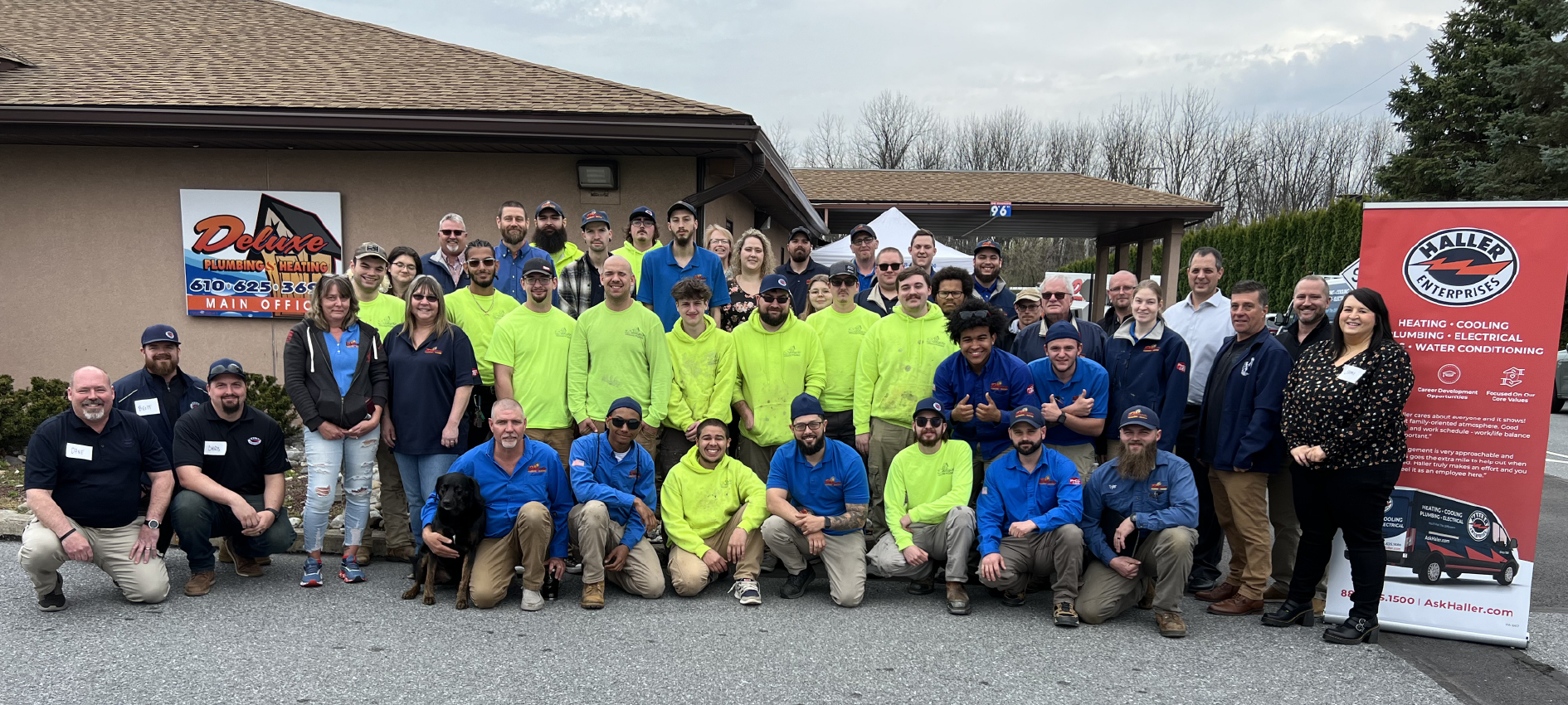 Team photo of Haller and Deluxe techs and employees in front of Deluxe Plumbing & Heating