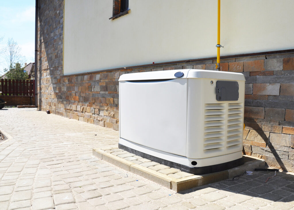 Generator on a concrete slab next to a house.