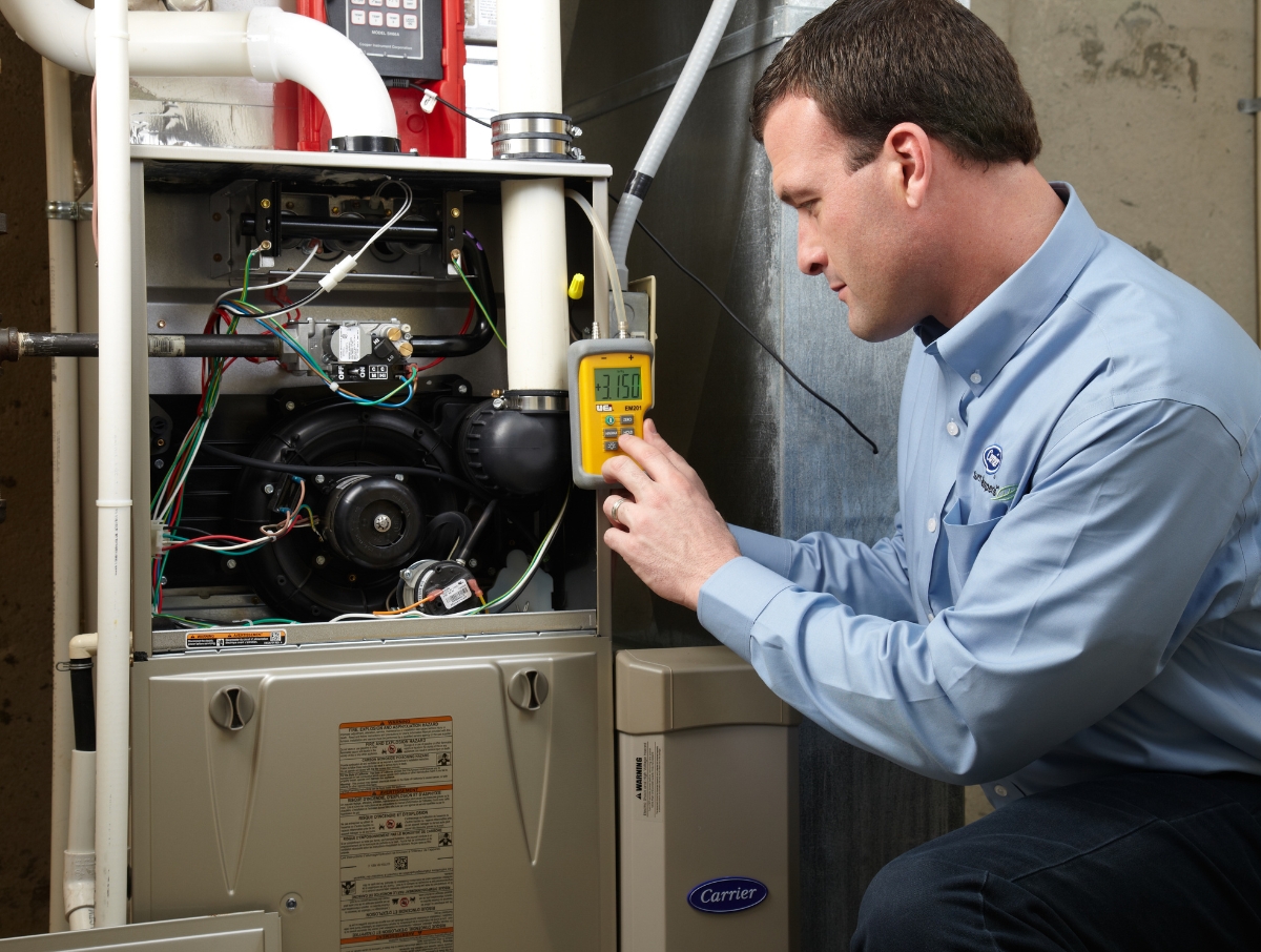 Technician running 27-point diagnostic testing on a furnace to ensure heating system is ready for winter in PA.