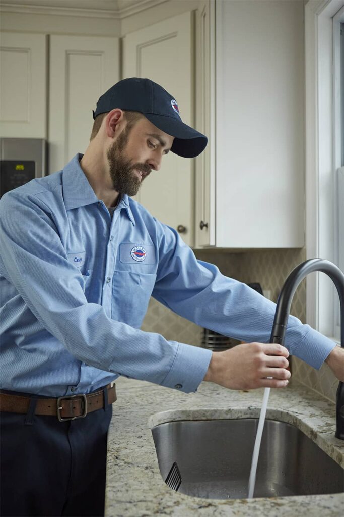 Haller plumber inspecting a kitchen sink faucet