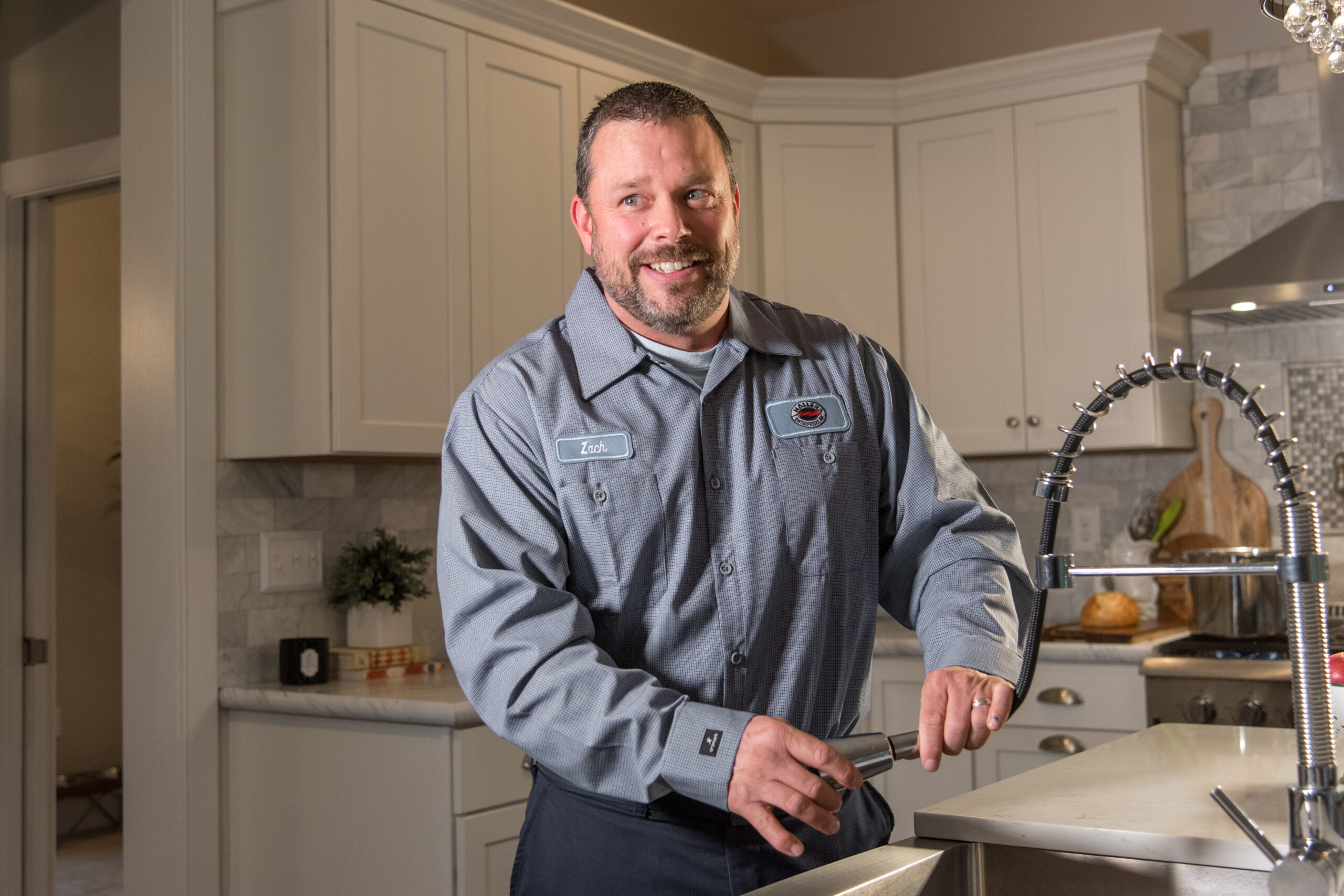 Friendly home service technician standing in completed kitchen project