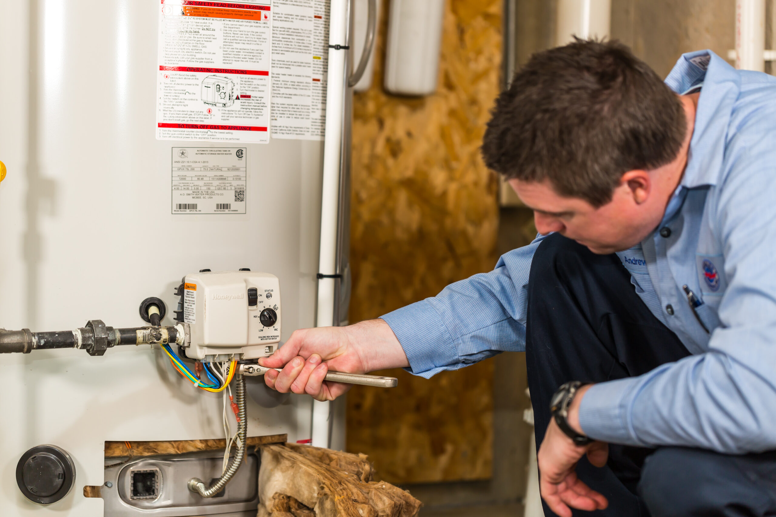 Technician adjusting residential water heater controls
