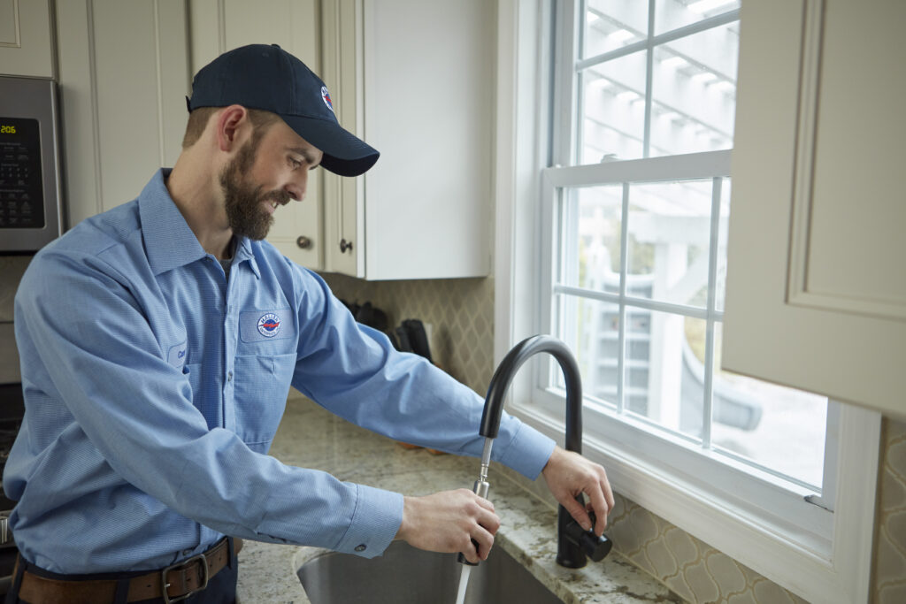 Haller Enterprises technician working on kitchen plumbing fixture