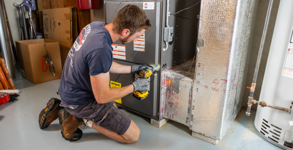 A Haller tech works on a furnace. He can help you answer, "Why does my furnace turn on and off frequently?"