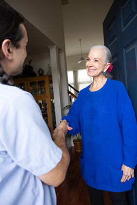 Haller technician greeting woman at her door with a handshake