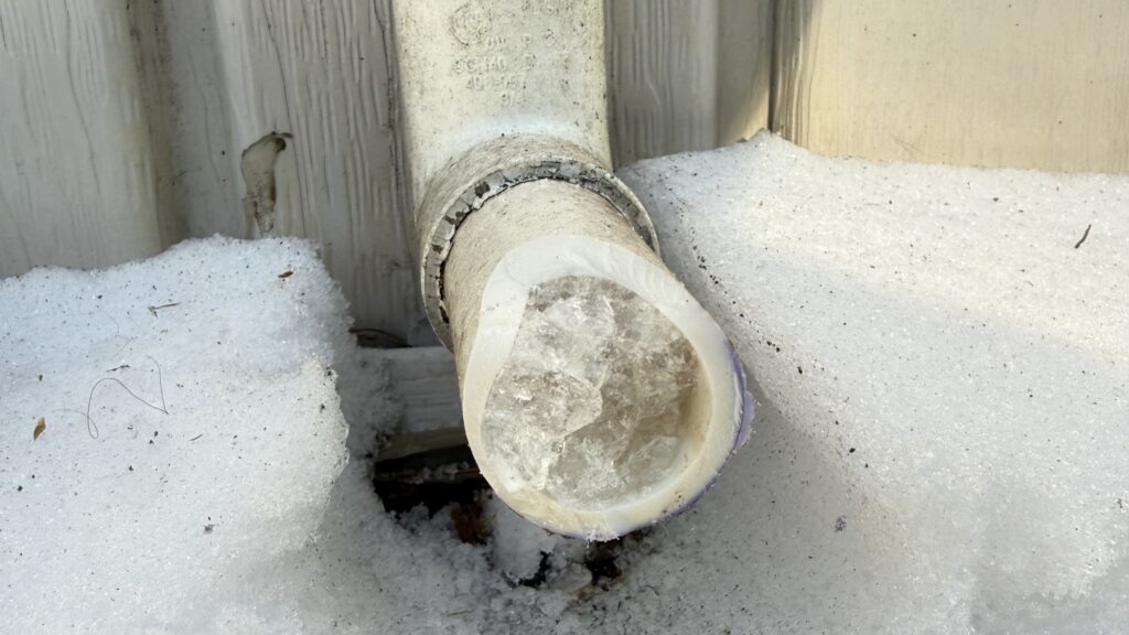 A frozen exterior PVC pipe is shown. Haller can provide tips for preventing frozen pipes during extreme cold in Pennsylvania