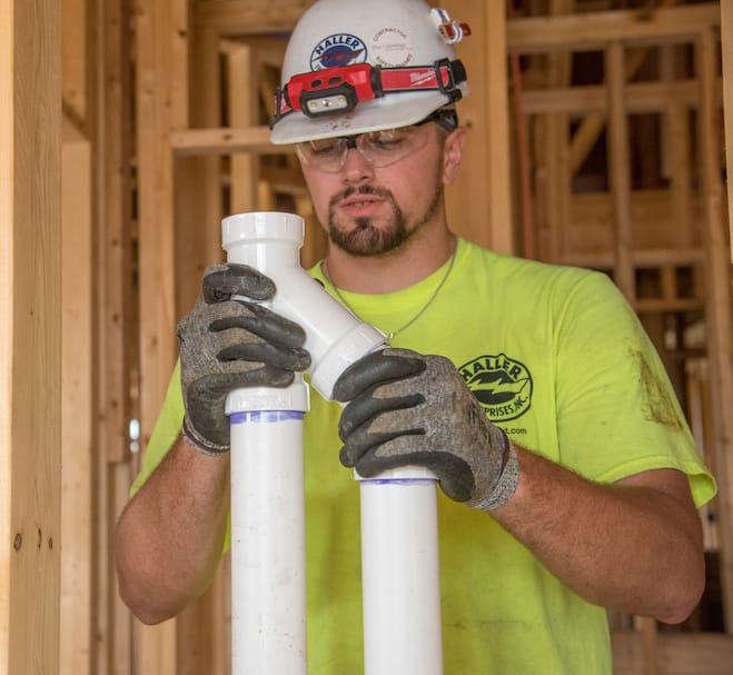 Plumber from Haller Enterprises Fitting a new PVC pipe