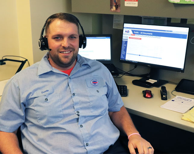 Technician sitting at computer ready to help