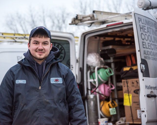 Haller HVAC technician outside van with new unit inside