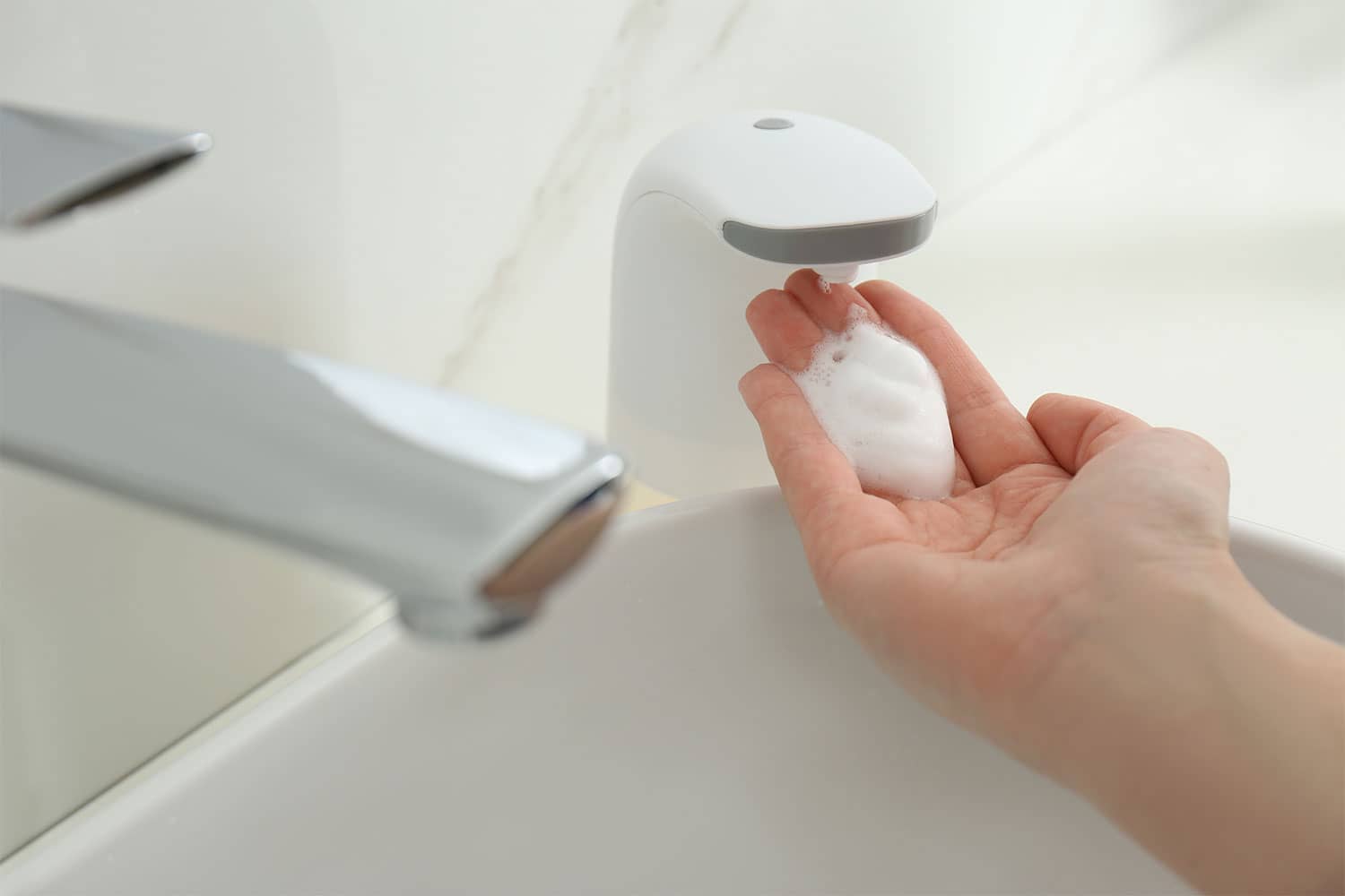 Person using automatic touchless soap dispenser