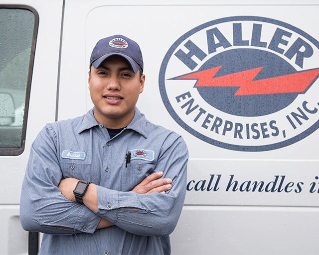 Haller Technician with his arms crossed in front of a truck