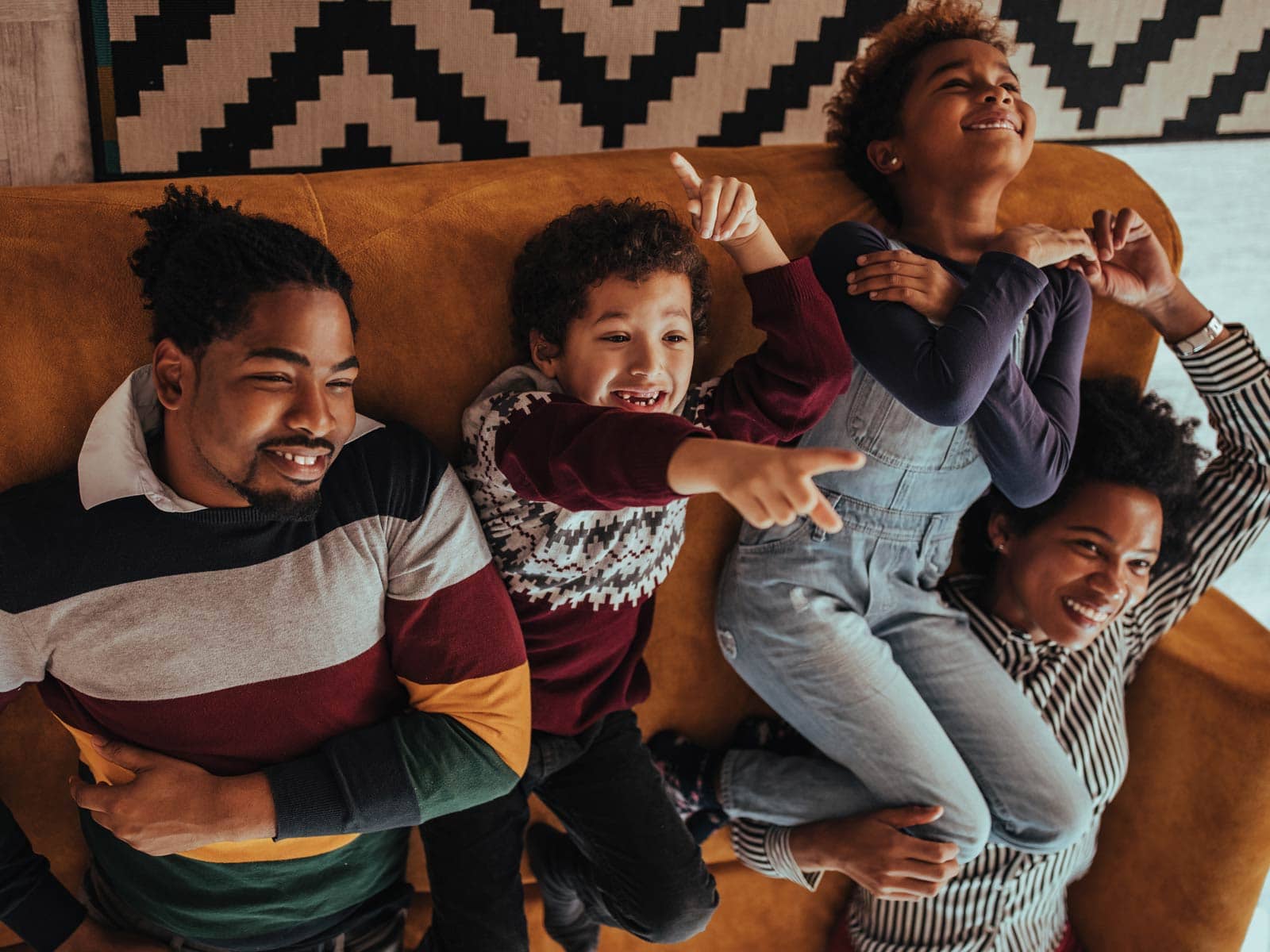 family laying on a couch upside down