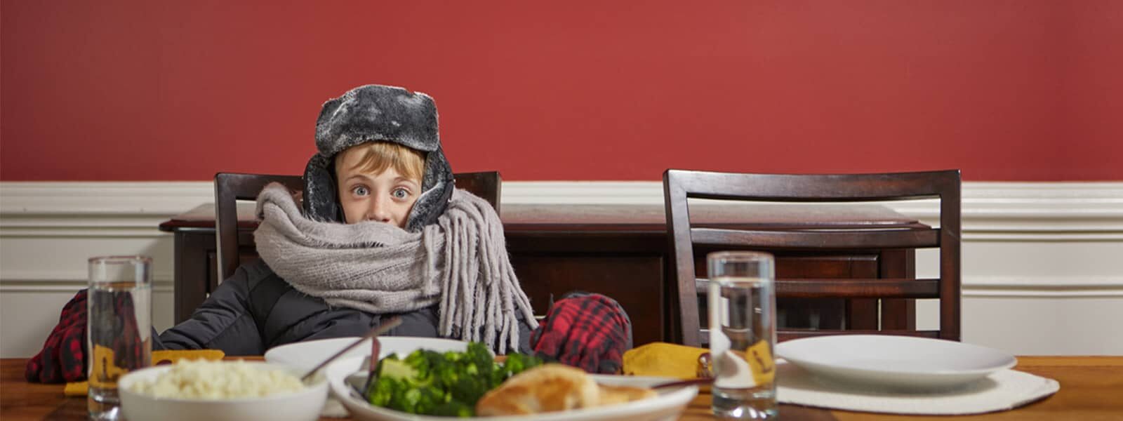 Young person with a jacket and scarf at the dining table