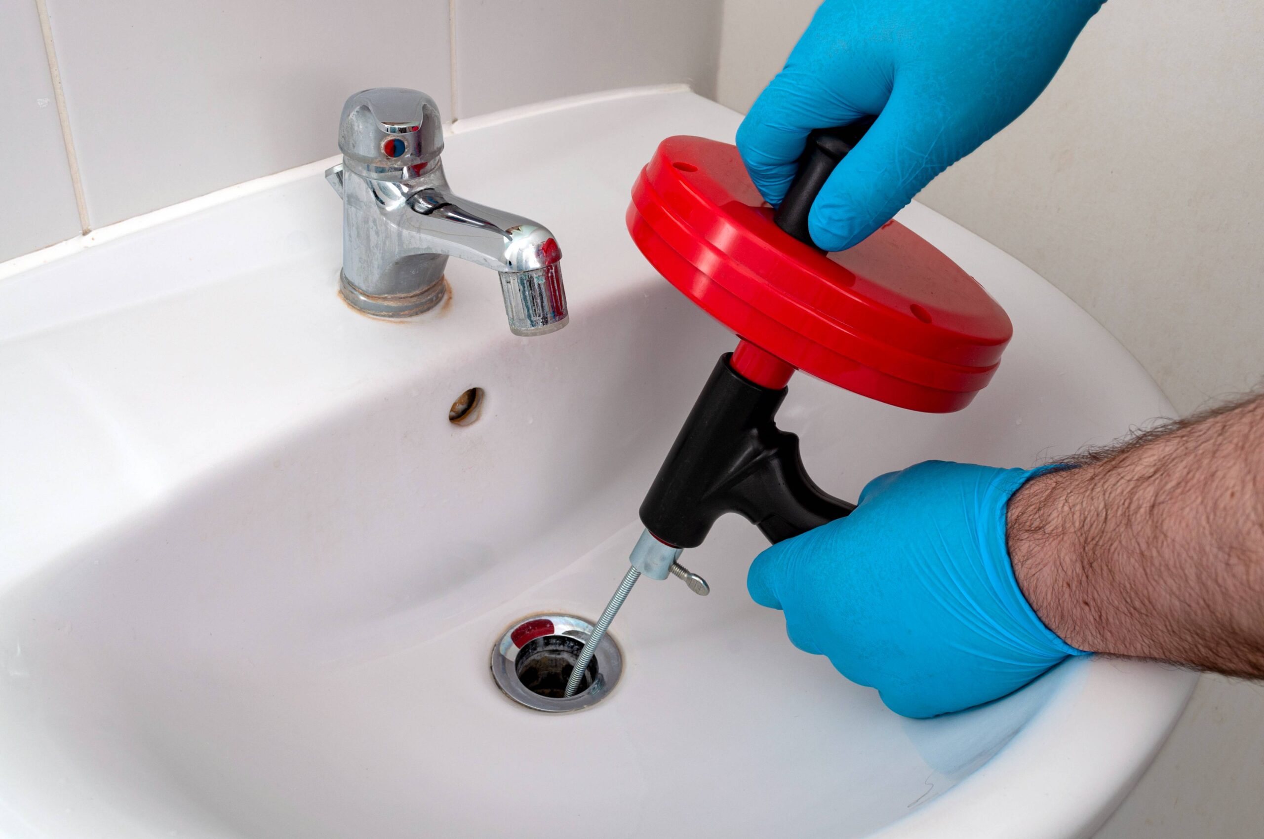 Drain snake cleaning a bathroom sink drain
